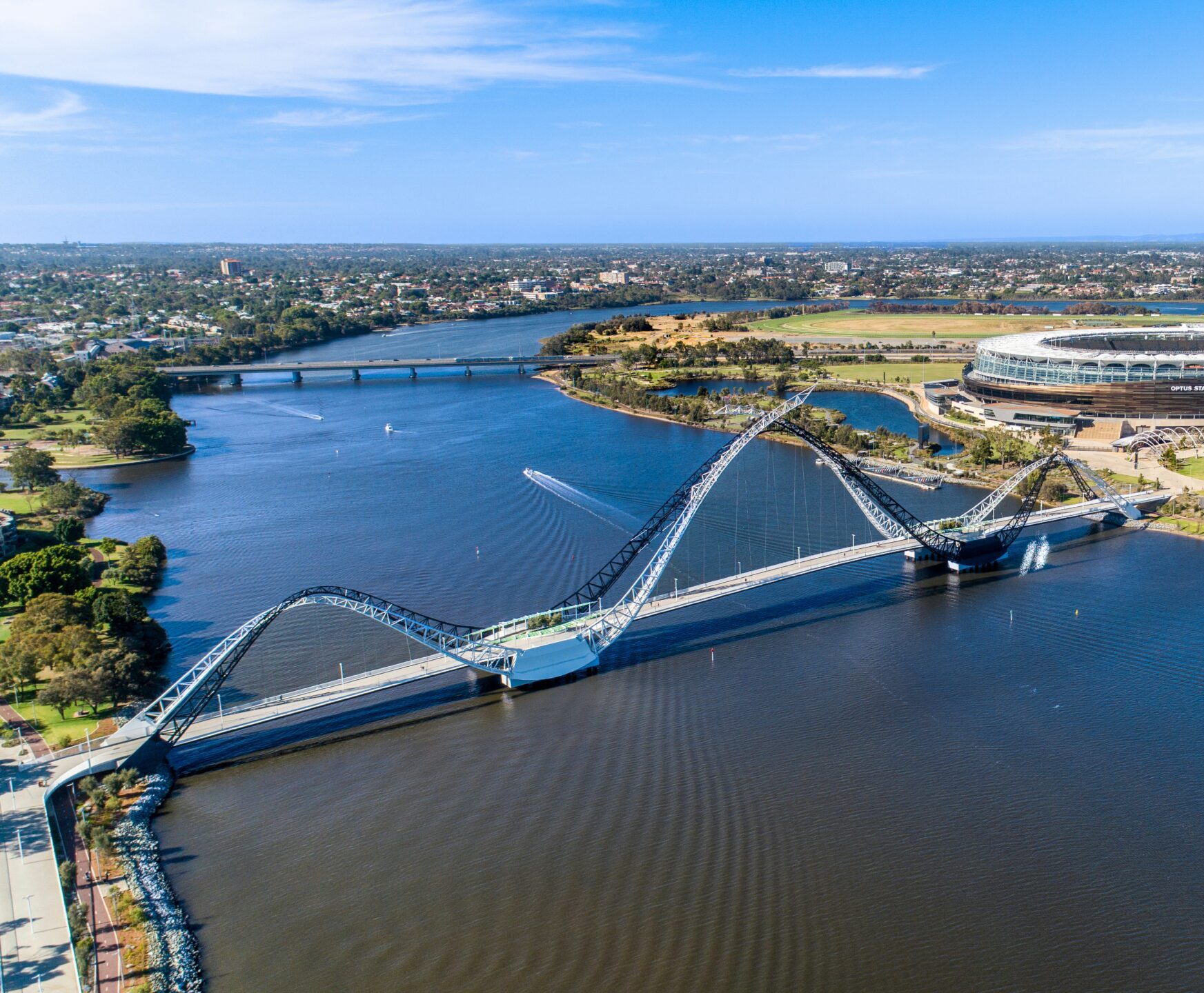 WA Gov: Aerial view of the Matagarup Bridge in Perth, Western Australia. The Swan River flows beneath the bridge, with Optus Stadium in the background.